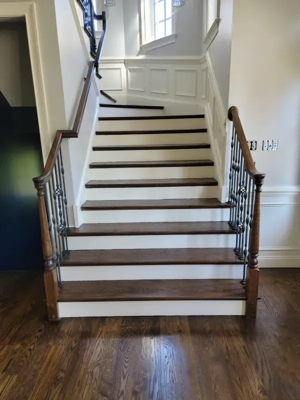 A staircase with white steps and wooden steps in a house.
